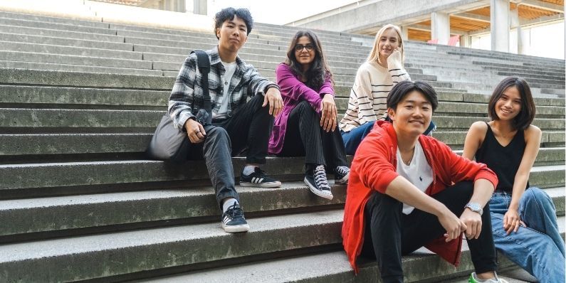 5 students sitting on the stairs of convocation mall